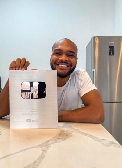 Tayo Aina poses with his YouTube plaque- Tayo is a Nigerian travel-lifestyle and real estate YouTuber, film-maker, and an African brand influencer form Nigeria